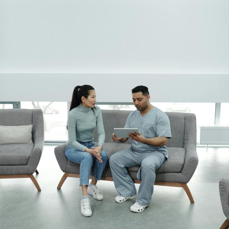 A Doctor Showing a Tablet to a Patient